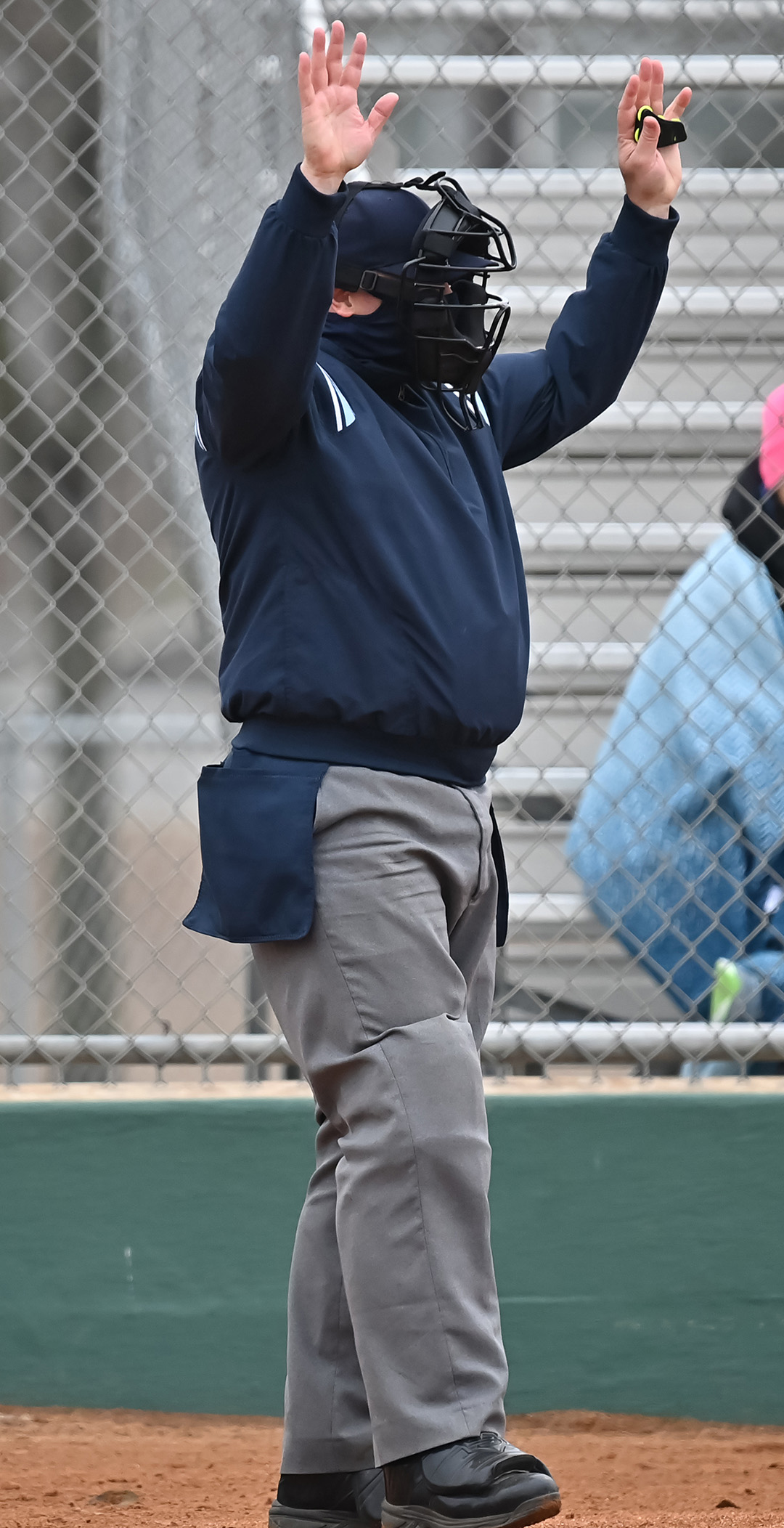 An umpire with both hands up in the air.